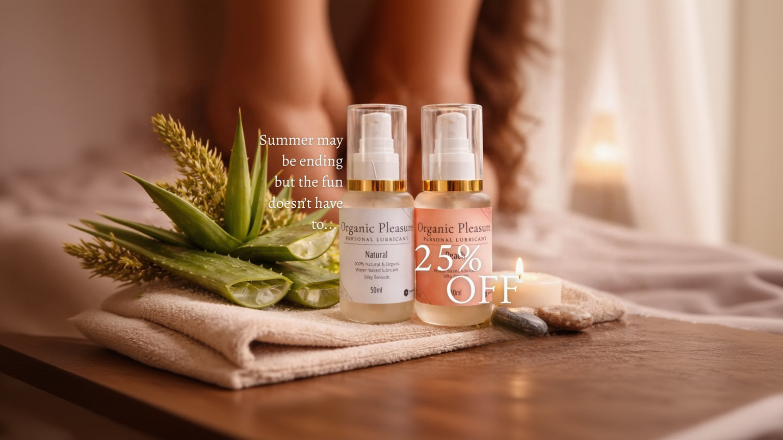 Two bottles of Organic Pleasure personal lubricant with aloe vera leaves and candles in the background.